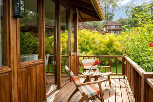 a wooden porch with two chairs on a deck at La Coralina Island House in Bocas del Toro