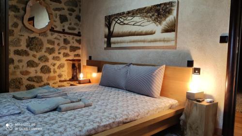 a bedroom with a bed with two pillows on it at Rock and Stone in Kalabaka