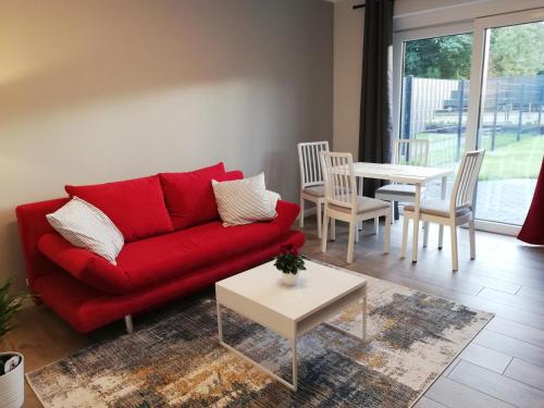 a living room with a red couch and a table at Ferienwohnung am Welper-Wald-Vechta-Süd in Vechta