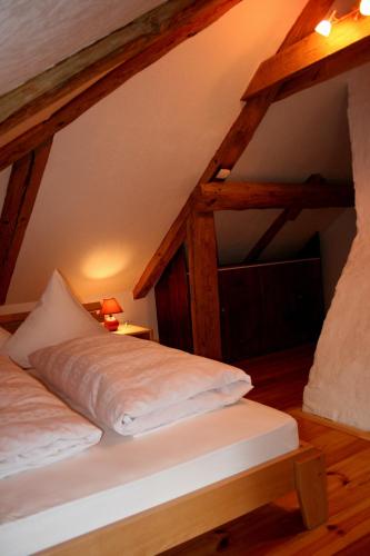 a bed in a room with wooden beams at Goldingen in Kuldīga