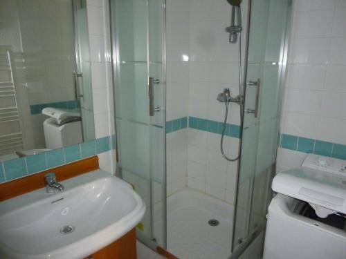 une salle de bain avec une douche en verre et un lavabo dans l'établissement JOLI STUDIO AVEC TERRASSE PROCHE PLAGES, à Cavalaire-sur-Mer
