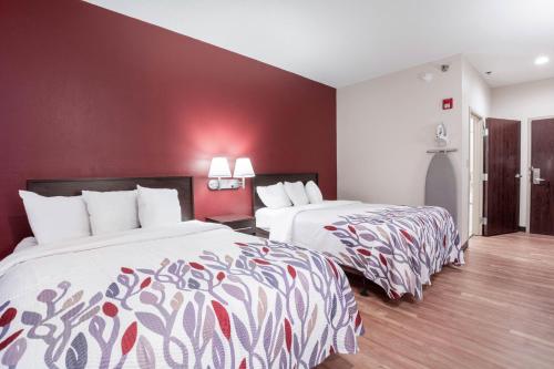 two beds in a hotel room with red walls at Red Roof Inn Richmond, KY in Richmond