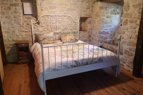una cama de metal con dos gatos sobre ella en Maison traditionnelle en Lozère, en Saint-Saturnin-de-Tartaronne