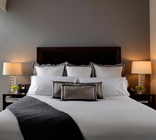a large bed with white pillows and two lamps at Trump International New York in New York