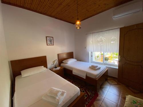 een slaapkamer met 2 bedden en een raam bij Old Town Hotel in Gjirokastër