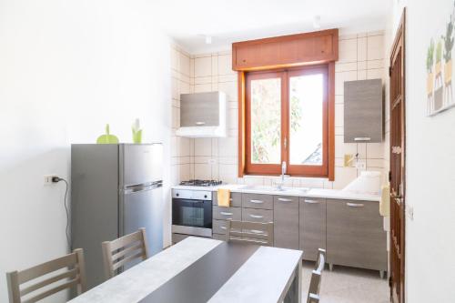 a kitchen with a table and a refrigerator at La Curte dellu Pippi Niuru in Lecce