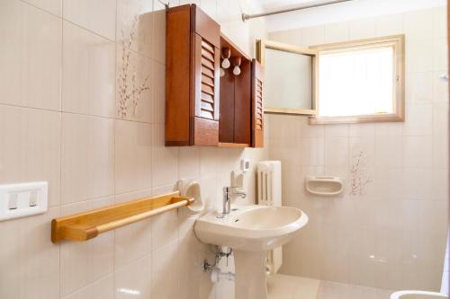 a bathroom with a sink and a toilet and a window at La Curte dellu Pippi Niuru in Lecce
