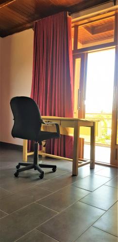 a office with a chair and a desk and a window at Isaro House Kigali in Kigali