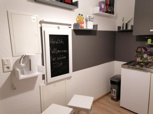 una pequeña cocina con una pizarra en la pared en Monteurs-Ferienwohnung, en Wolfhagen