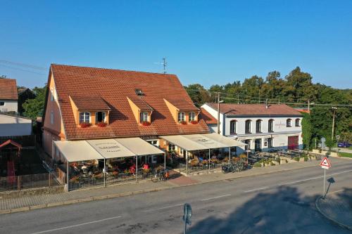 a building with tables and chairs in front of a street at Penzion u Tesaru in Bítov