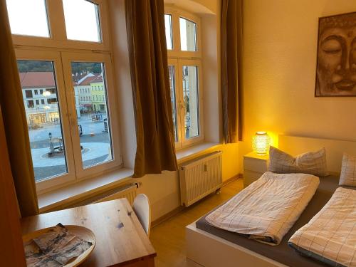 Pokój z 2 łóżkami, stołem i oknami w obiekcie Apartment Altstadt-Panorama w mieście Meiningen