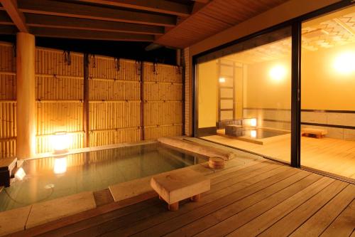 a room with a swimming pool with a bench in it at Hotel Yumeshizuku in Minami Aso