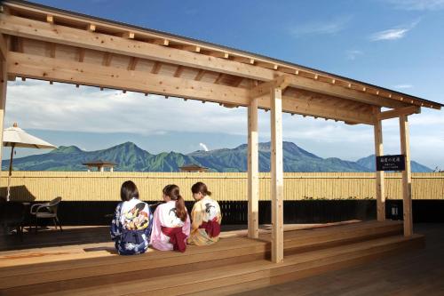 three young girls sitting on a wooden deck at Hotel Yumeshizuku in Minami Aso