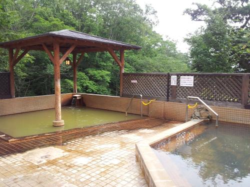 a pool of water with a wooden gazebo at Niseko Grand Hotel in Niseko