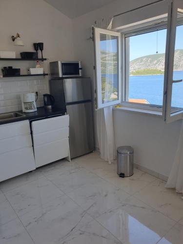 a kitchen with a refrigerator and a window with a view of the ocean at Luxury apartment Korcula - Villa Sunny Days in Korčula