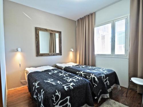 a hotel room with two beds and a mirror at Keskuskuja 5 A1 ja A4, Levin Alppikeskus in Levi
