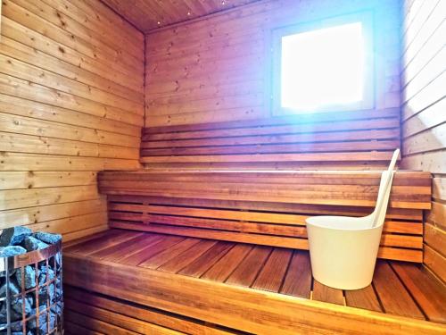 a wooden sauna with a white bucket in it at Keskuskuja 5 A1 ja A4, Levin Alppikeskus in Levi