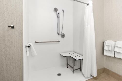uma casa de banho com um chuveiro e uma cortina de chuveiro branca em Holiday Inn Express & Suites - Suisun City, an IHG Hotel em Suisun City
