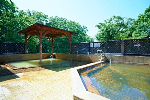 a swimming pool with a wooden gazebo and a swimming poolvisorangering at Niseko Grand Hotel in Niseko