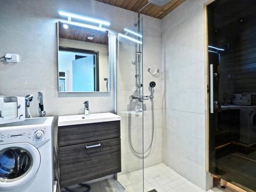 a bathroom with a shower and a washing machine at Levin keskusta, Tunturinlaita B9 in Levi