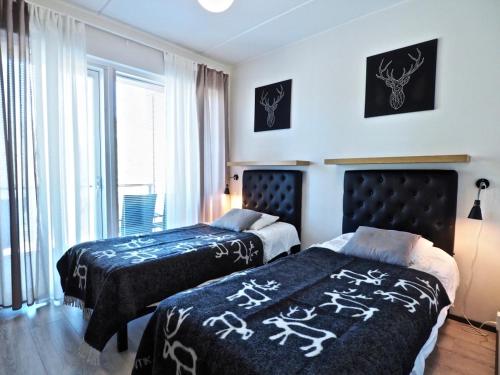 a bedroom with two beds and a window at Levin keskusta, Tunturinlaita B9 in Levi