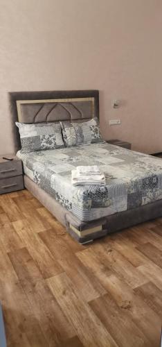 1 cama en un dormitorio con suelo de madera en Comforts apartments 1 en Fnidek