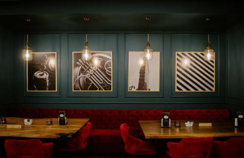 a restaurant with two tables and pictures on the wall at Hotel Boutique Vila 135 in Tirana