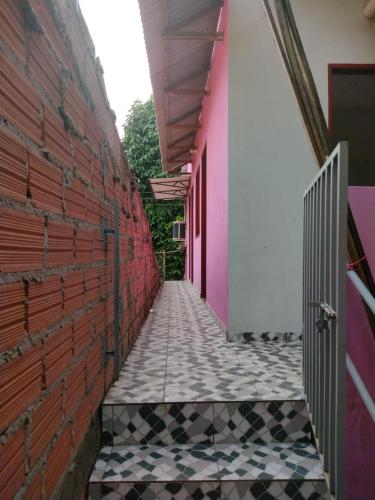 a corridor of a building with pink and black tiles at Pousada Sombra do Jambeiro in Alter do Chao