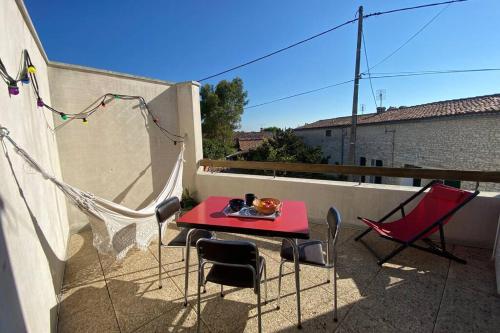 d'une terrasse avec une table et des chaises rouges sur un balcon. dans l'établissement Maison au coeur de Meschers - proche des plages, à Meschers-sur-Gironde