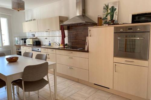 uma cozinha com uma mesa e um fogão forno superior em Maison au coeur de Meschers - proche des plages em Meschers-sur-Gironde