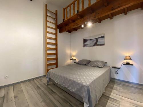 - une chambre avec un lit et un escalier en bois dans l'établissement Duplex des études - Carcassonne centre, à Carcassonne