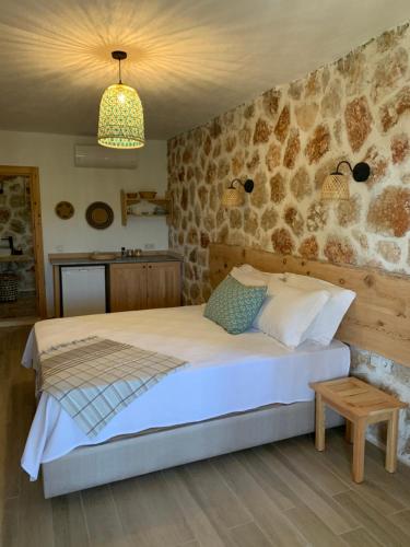 um quarto com uma cama com uma parede de pedra em Melihaus em Cukurbag