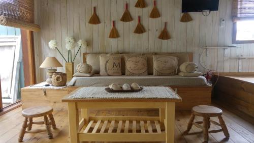 a room with a bed and a table and stools at Cabañas Las Achiras in Punta Del Diablo