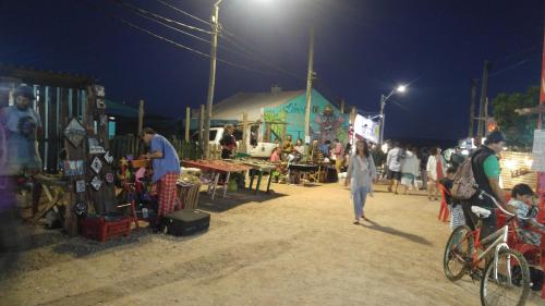 a group of people walking around a market at night at Cabañas Las Achiras in Punta Del Diablo