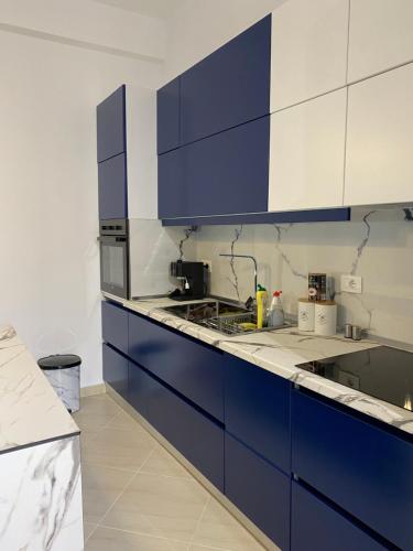 een keuken met blauw-witte kasten bij Enid Apartment in Vlorë