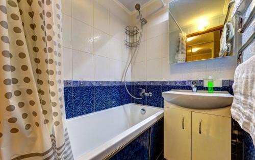 a bathroom with a tub and a sink and a shower curtain at ТОП 1к квартира метро Лукьяновка, Юрия Ильенка 49 in Kyiv