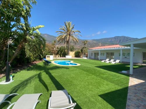 a yard with chairs and a swimming pool at Arafo Sunset Villa in Arafo