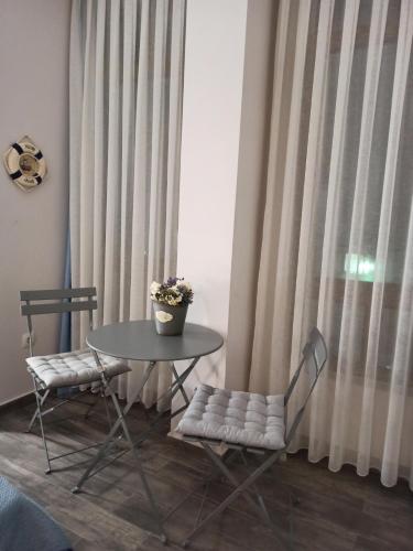 a table and two chairs and a table with a potted plant at Art Blue Apartments in Ohrid