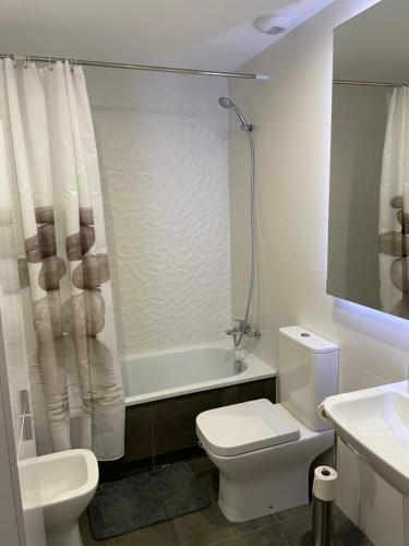 La salle de bains est pourvue de toilettes, d'un lavabo et d'une douche. dans l'établissement Apartamento exclusivo playa granada golf, à Motril