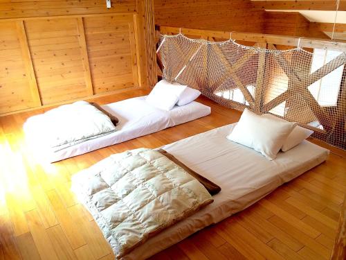 une chambre avec 2 lits et une moustiquaire dans l'établissement Karin Design Cottage, à Onna