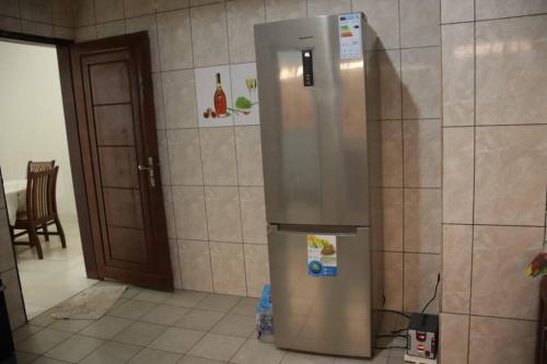 a kitchen with a stainless steel refrigerator in a room at Résidence Jeanne à Yaoundé Odza Messamengo in Yaoundé