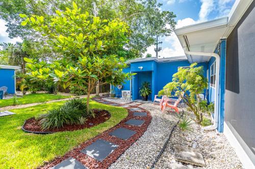 einen Garten mit einem blauen Haus mit einem Baum in der Unterkunft The Blue House Fort Lauderdale Airport/Cruise in Fort Lauderdale