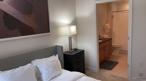 a bedroom with a bed and a bathroom with a sink at National at Loudoun in Ashburn