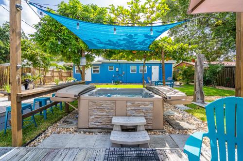 uma banheira de hidromassagem num quintal com uma rede de descanso em The Blue House Fort Lauderdale Airport/Cruise em Fort Lauderdale