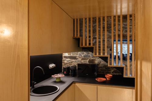 a kitchen with a sink and a microwave at Story Studio Piódão - Heritage in Piódão