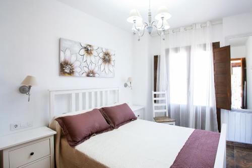 1 dormitorio con 1 cama y una pintura en la pared en Casa rural Torre Buena Vista a 40 minutos de Valencia con gran jacuzzi y vistas maravillosass, en Benafer