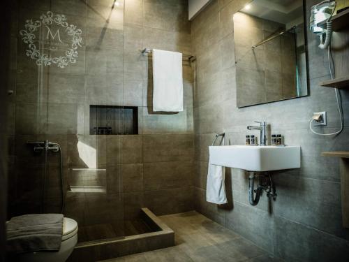 a bathroom with a sink and a toilet and a shower at Villa Marelia apartments in Aliveri