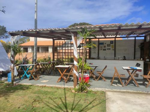 a group of tables and chairs under a pavilion at Primitivo glamping buzios in Búzios