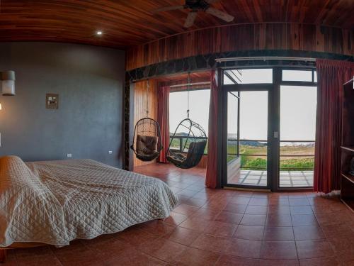 - une chambre avec un lit et des balançoires dans l'établissement Sunset Vista Lodge,Monteverde,Costa Rica., à Monteverde Costa Rica