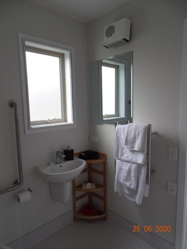 a white bathroom with a sink and a mirror at Lodges On Pearson Unit 1 in Cromwell